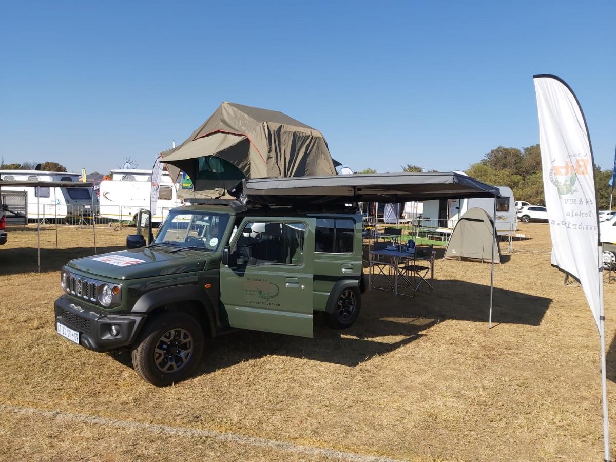 The Suzuki Jimny 5 door 4x4 with roof top tent and awning open.