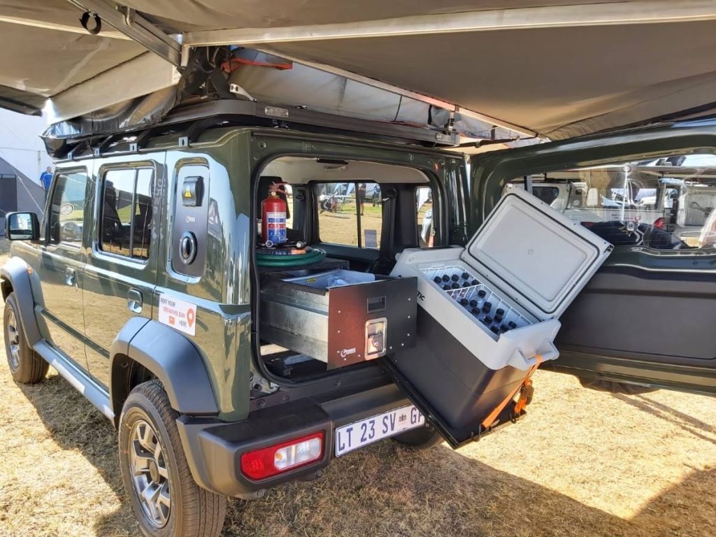 A Suzuki Jimny 5 door 4x4 camper with a slide-out fridge.