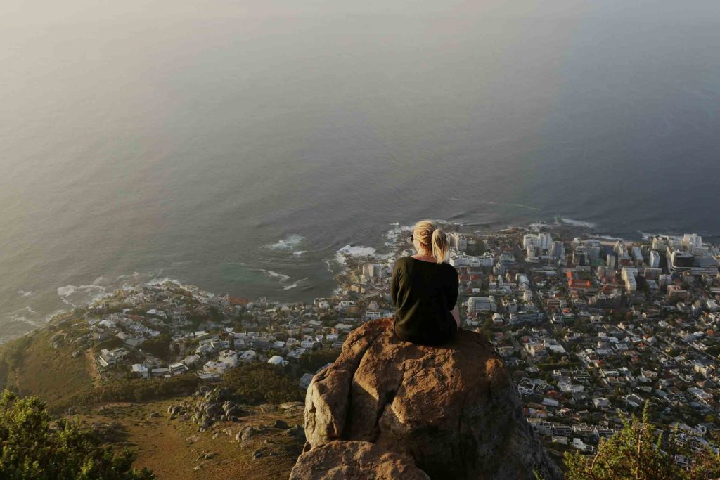 A woman sits atop Lions Head in Cape Town.